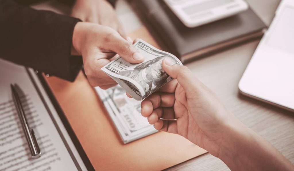 két ember pénzt ad át egymásnak. Az angol salary szó etimológiájának illusztrációja.